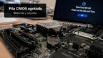 Pila CMOS de una placa base junto a un PC que ha perdido la fecha y la hora
